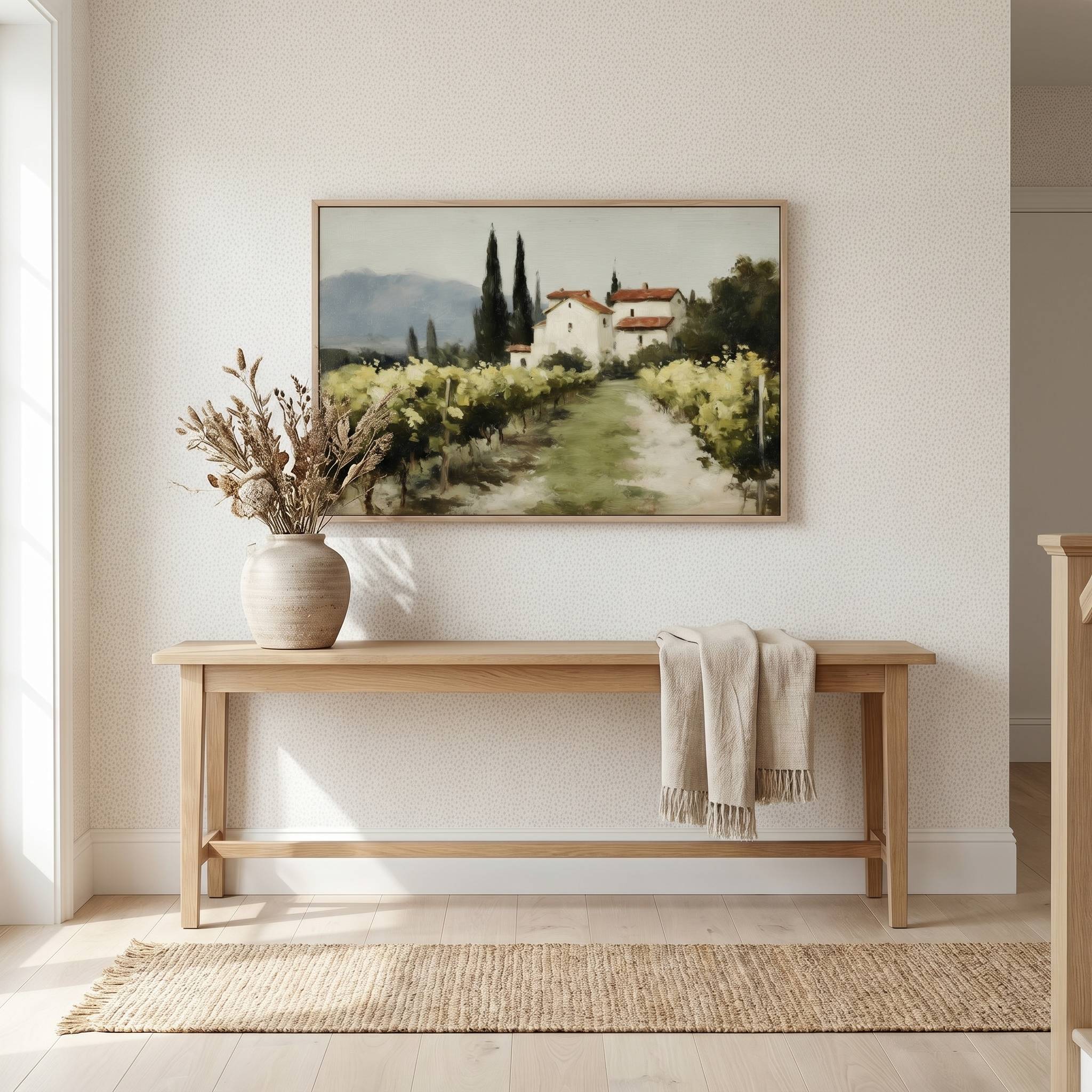 The Vineyard Christian landscape wall art displayed above a wooden entryway console table, featuring a peaceful vineyard and countryside home that symbolizes abiding in Christ, spiritual growth, and God's faithful provision.