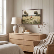 Framed vintage Christian wall art featuring Jesus walking through a peaceful wildflower meadow, displayed above a light wood dresser in a soft organic modern bedroom.