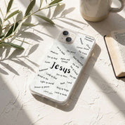 Phone case with 'Jesus' and religious text on a light surface with a plant and mug in the background